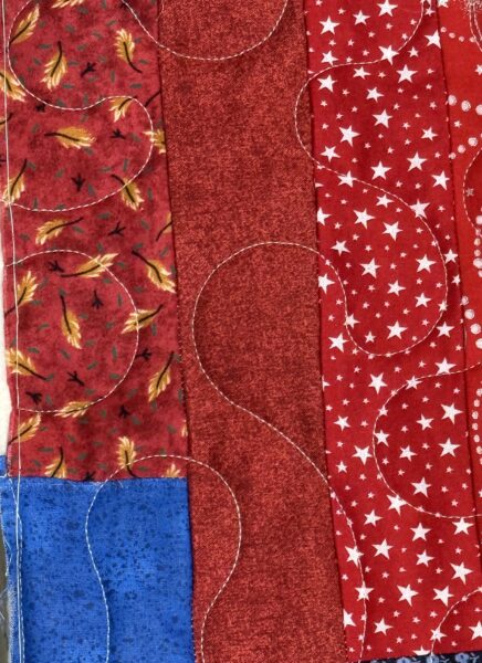 Close-up of fabric prints and meander quilting texture on JoAnne Scafidi's patriotic quilt