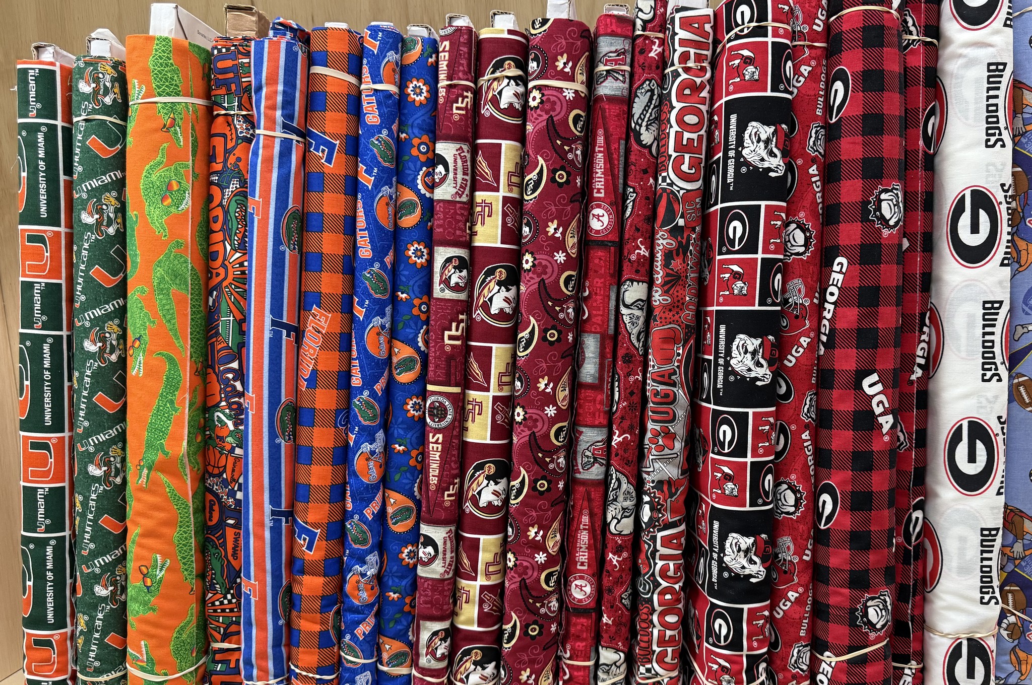 Collegiate team print cotton fabric bolts on the shelf