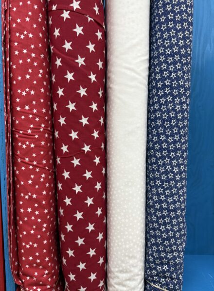 Patriotic red, white, and blue 108 inch wide cotton quilt backing fabric bolts on the shelf at Lady Bird Quilts